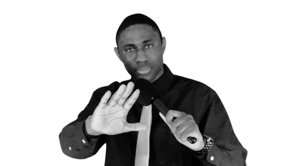 Prophet Lucky Perete holding a microphone with one hand raised.