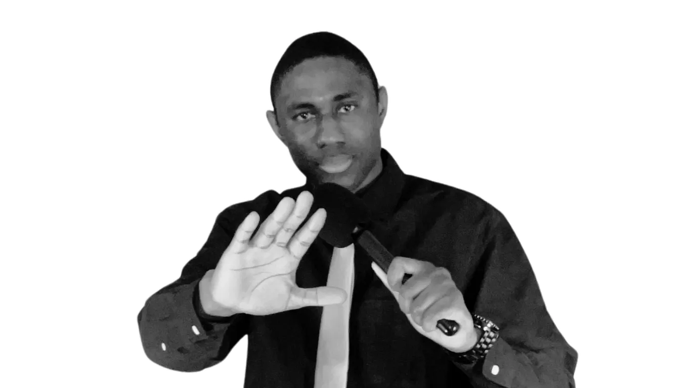 Prophet Lucky Perete holding a microphone with one hand raised.